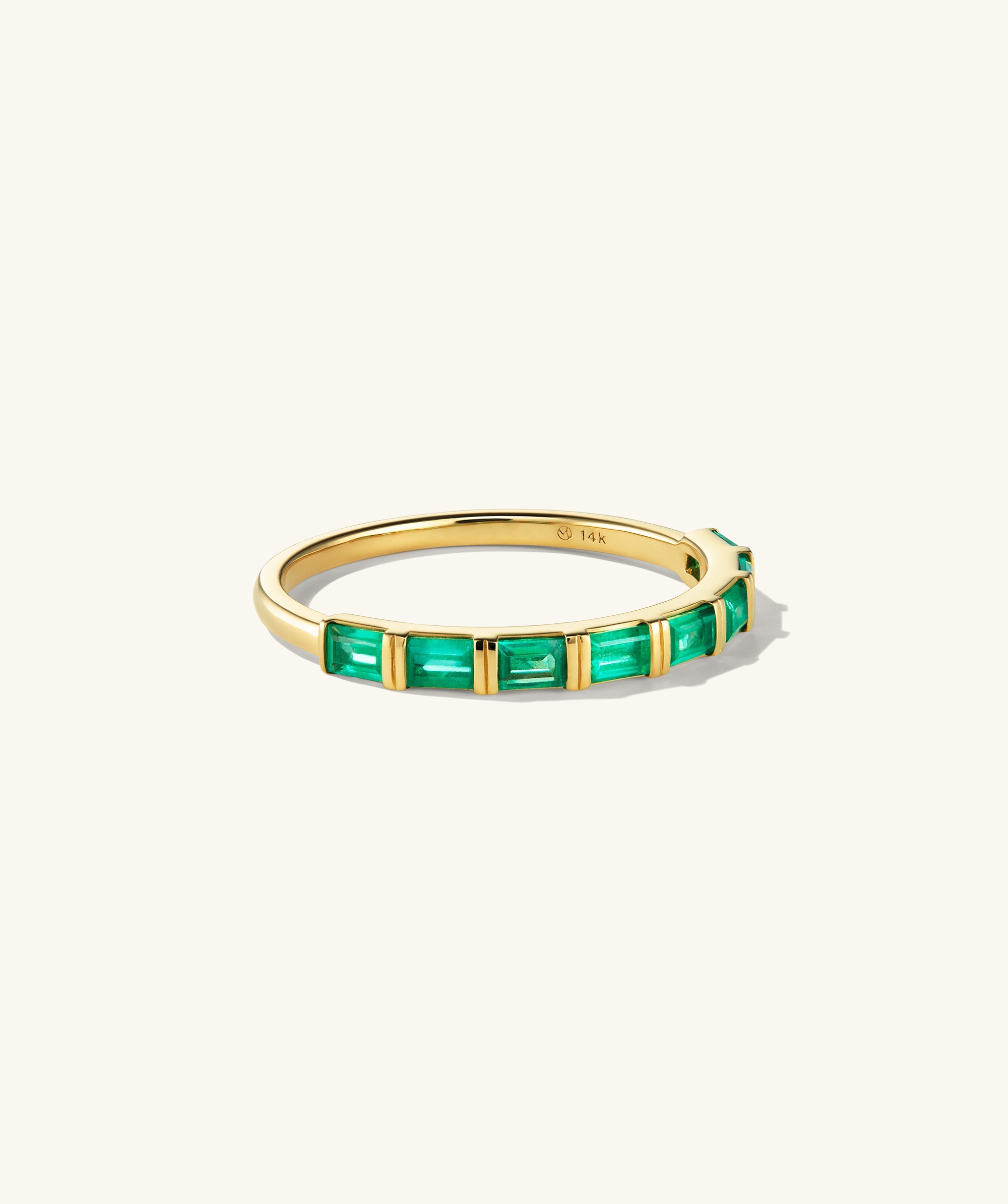 Baguette Emerald Half Eternity Band: A gold ring featuring eight baguette-cut emeralds set in a handcrafted 14k gold band.