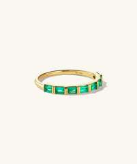 Baguette Emerald Half Eternity Band: A gold ring featuring eight baguette-cut emeralds set in a handcrafted 14k gold band.