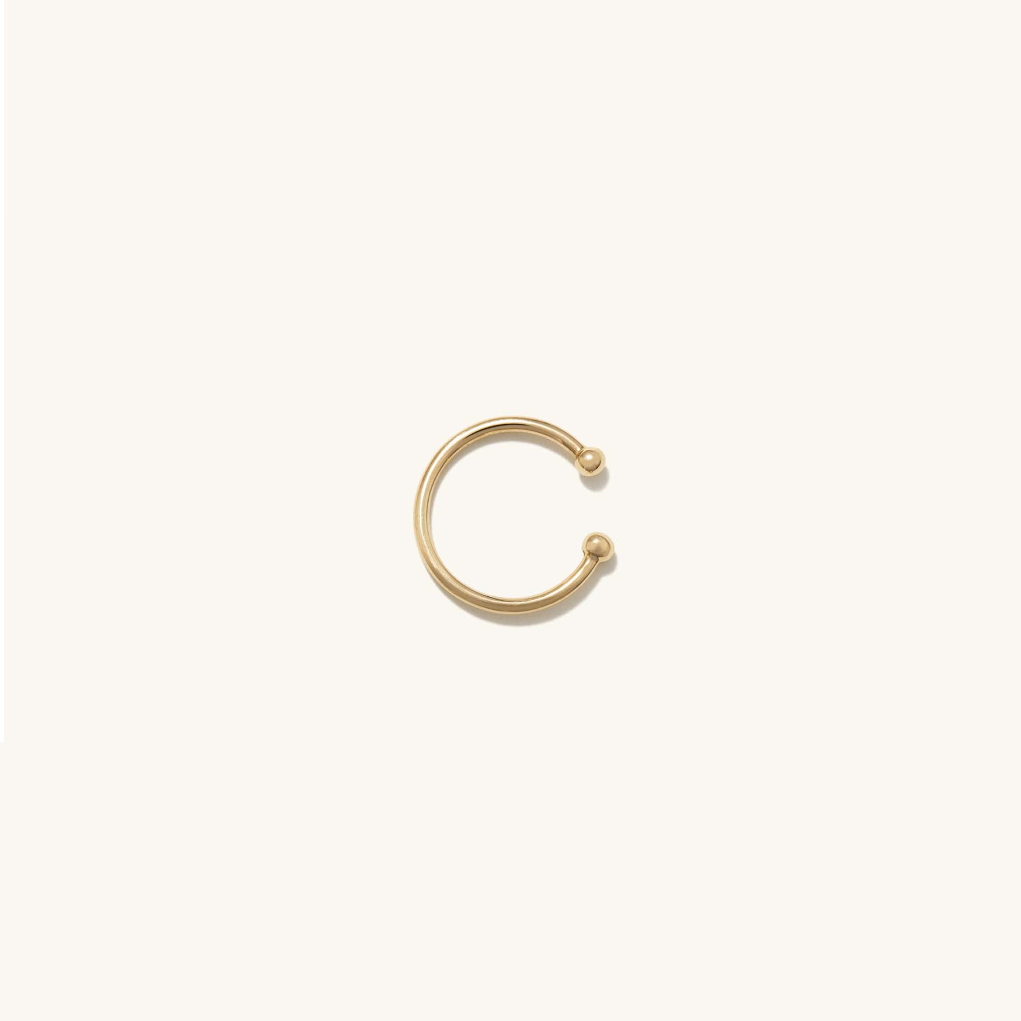 Essential Cuff: A handcrafted 14k solid gold ear cuff featuring a sleek, circular design with a polished ball accent, perfect for enhancing any jewelry stack.