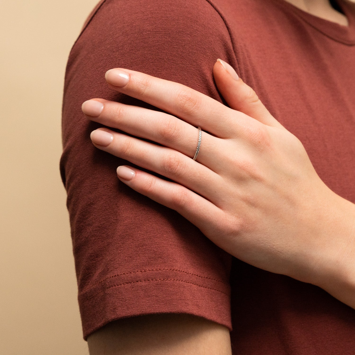 A person wearing the Diamonds Team Ring, featuring a delicate design perfect for stacking and complementing any outfit.