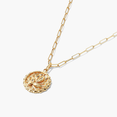 Balance: Terra Coin Charm Pendant, a close-up of a gold necklace with a round medallion featuring intricate design, inspired by Greek Goddess Gaia.