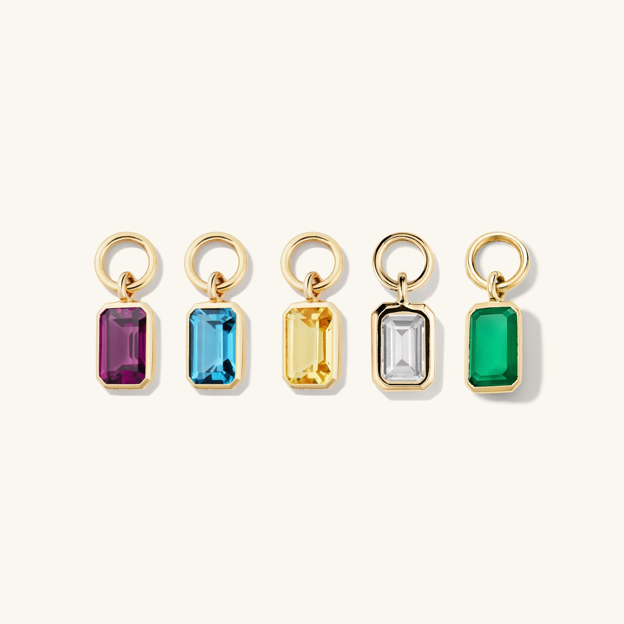 Single Emerald Cut Gemstone Hoop Charm displayed among various gemstones, highlighting its unique design for personalizing and enhancing everyday hoop earrings.