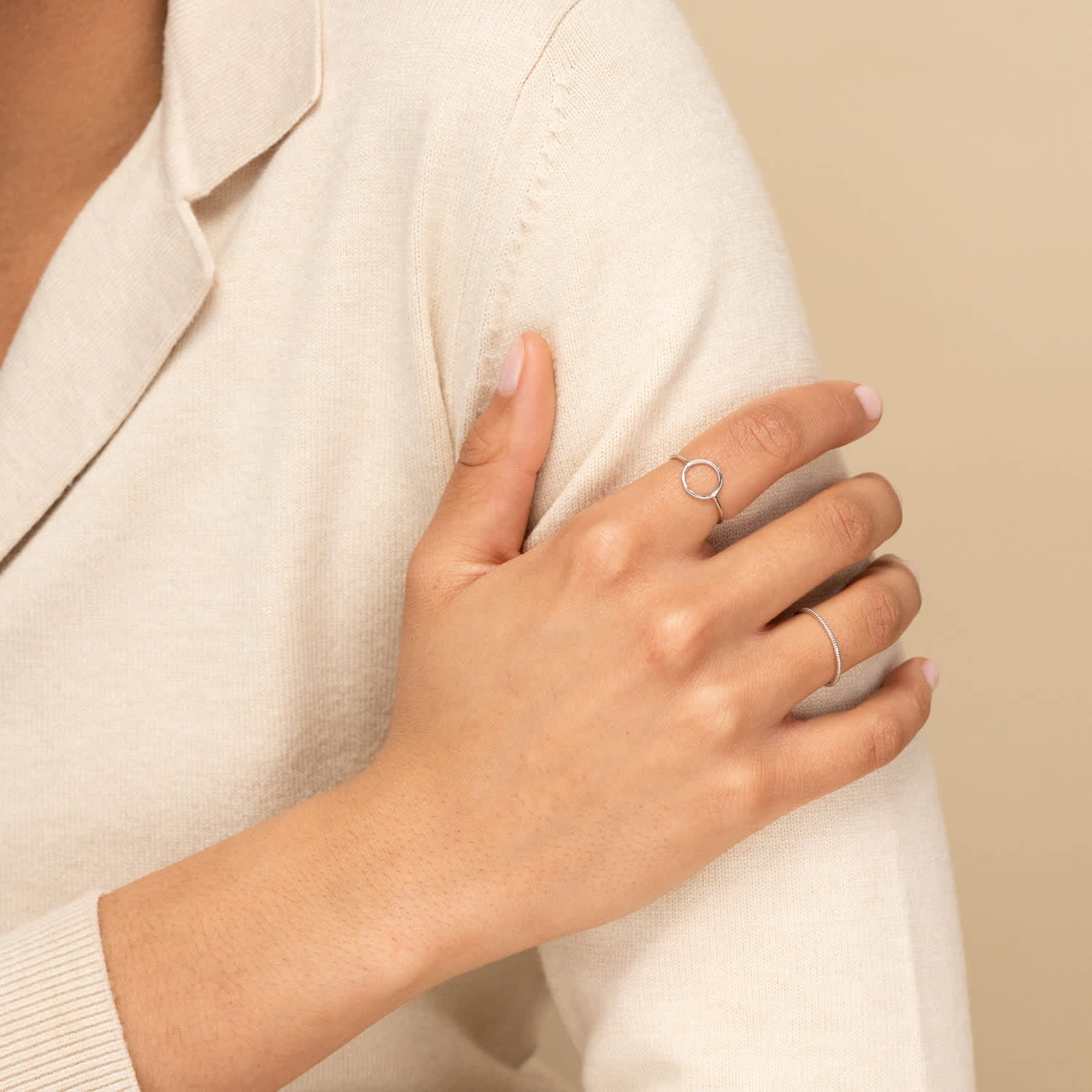 Close-up of a woman's hand wearing the Twist Ring, showcasing its delicate 1.3 mm band and intricate twisted pattern, highlighting its daily wear appeal.