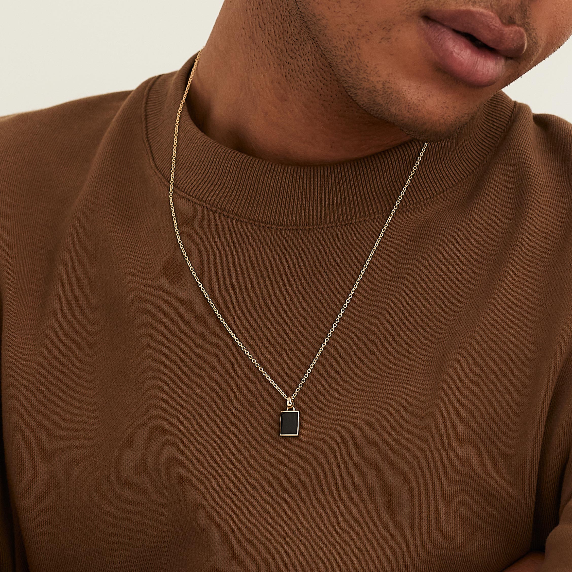 Man wearing a Black Onyx Pendant Necklace, showcasing the elegant design with a strong touch of onyx as a fashion accessory.