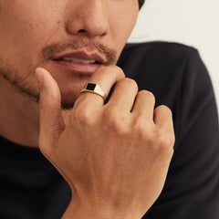 Close-up of a man's hand wearing the Black Onyx Square Signet Ring, highlighting its bold, square design and elegant onyx stone.