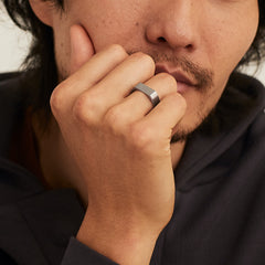 Man wearing the Slim Rectangular Signet Ring on his finger, shown in a close-up shot highlighting the ring's bold, substantial design.