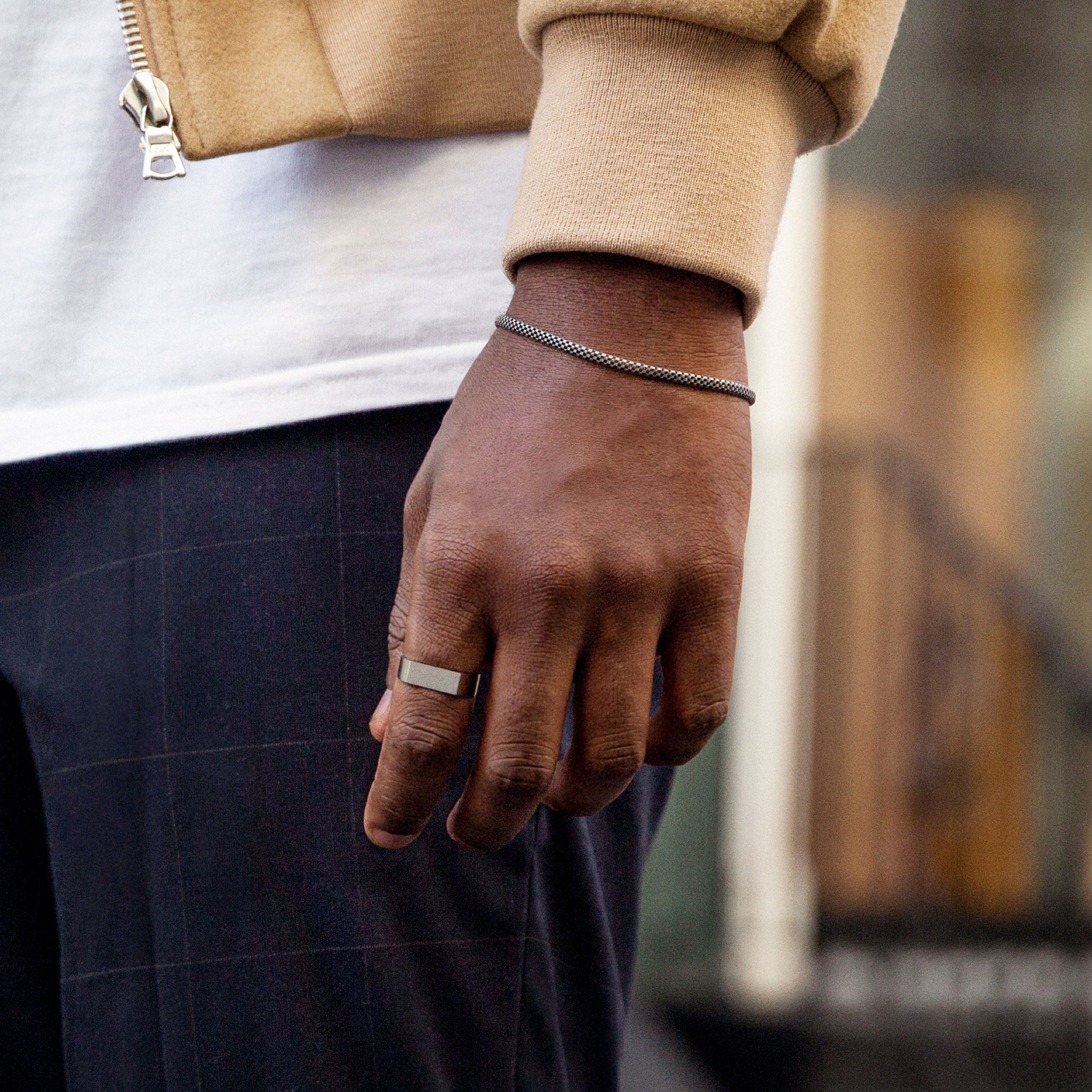 Close-up of a hand wearing the Slim Rectangular Signet Ring, showcasing its bold, substantial design on the finger.