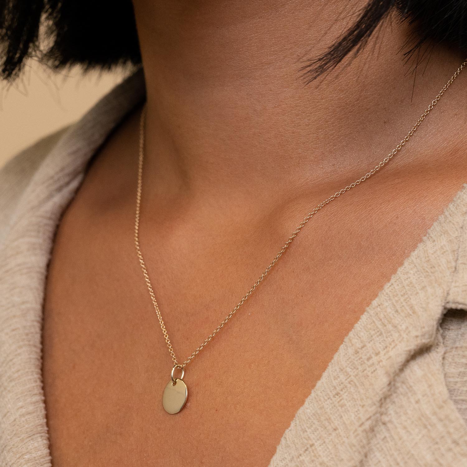 Woman wearing Engravable Charm necklace, close-up of the customizable pendant designed for personalizing or gifting.