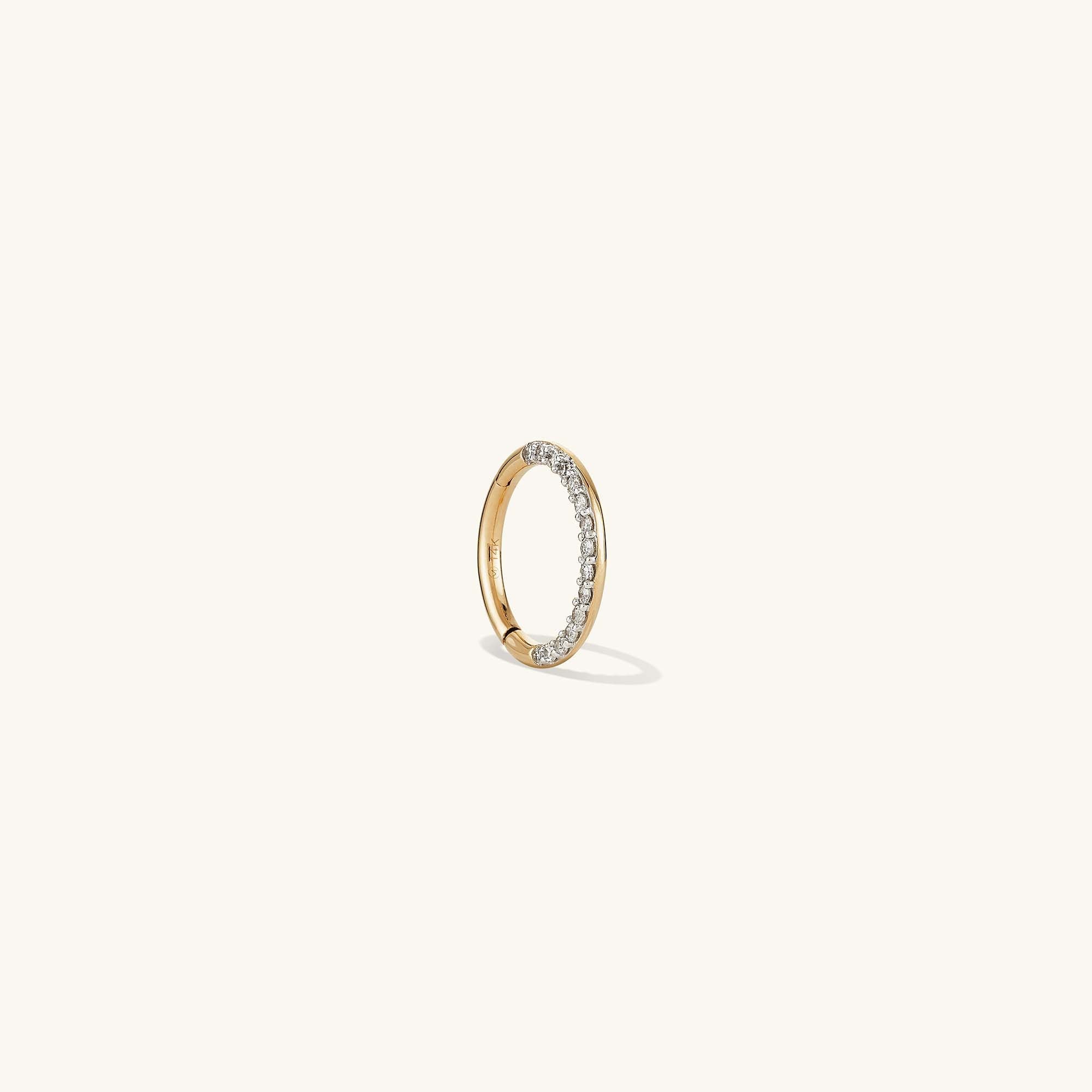 Cartilage PavÃ© Diamond Mini Hoop: A close-up of a 14k gold mini hoop earring with a pavÃ© diamond setting and hinge clasp for easy wear.