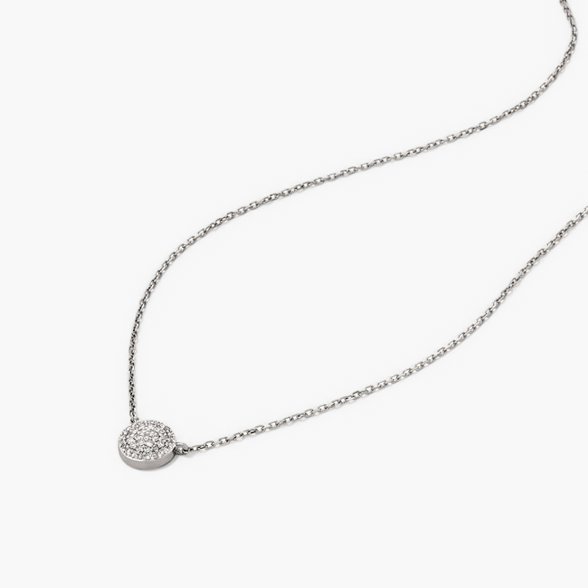 Large PavÃ© Diamond Round Necklace featuring a round pendant, handcrafted in 14k solid gold with pavÃ©-set responsibly sourced diamonds, displayed with small pebbles in the background.