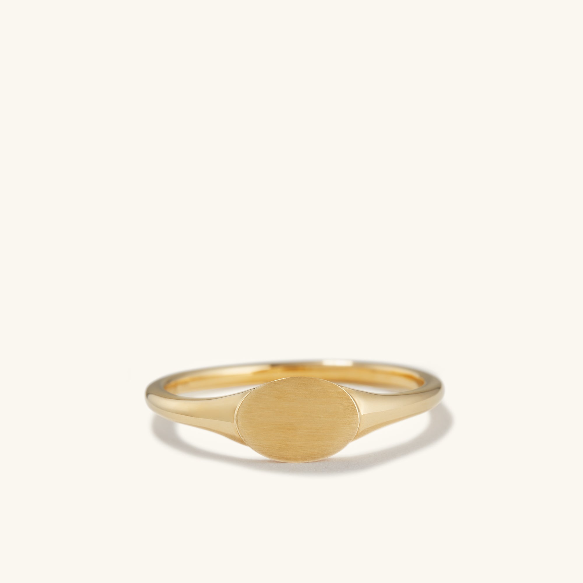 Signet Ring: A close-up of a 14k solid gold ring with a circular bezel, perfect for engraving an initial.