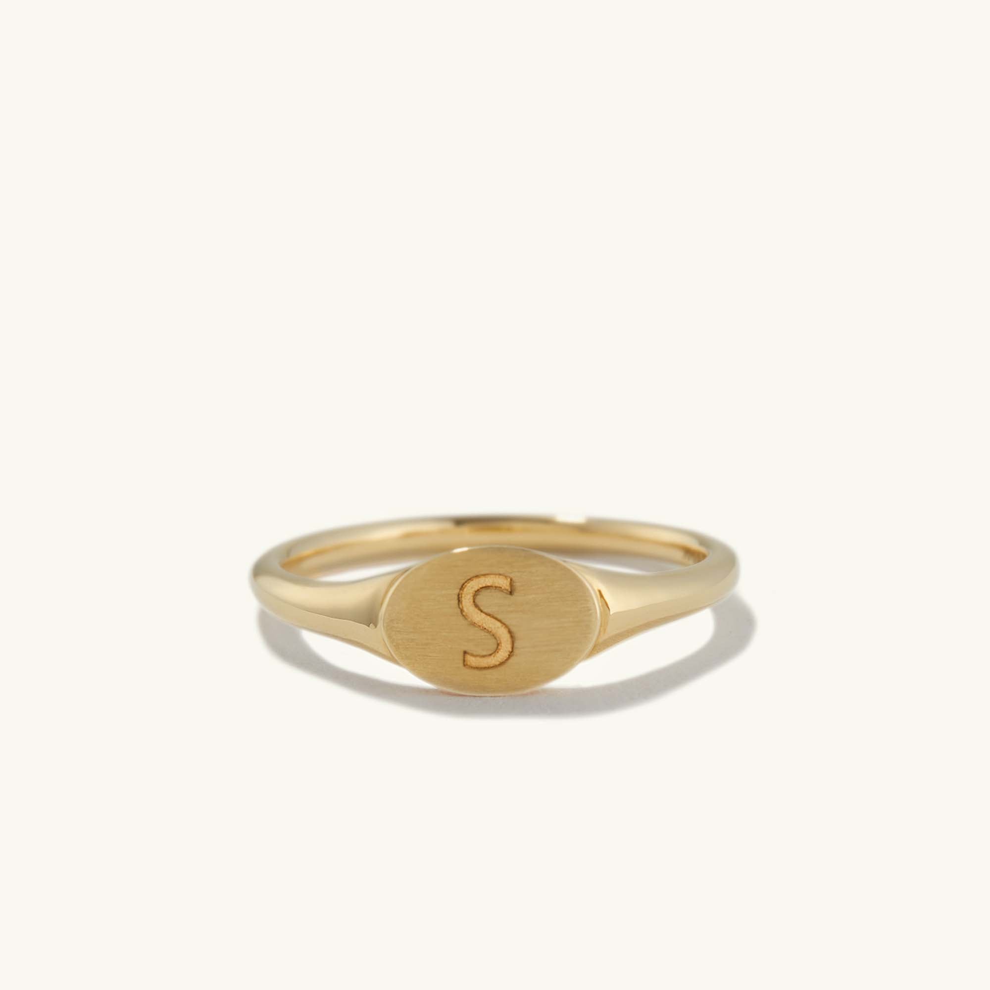 Gold signet ring engraved with the letter S, featuring a smaller, bold design in 14k solid gold with a customizable bezel surface.