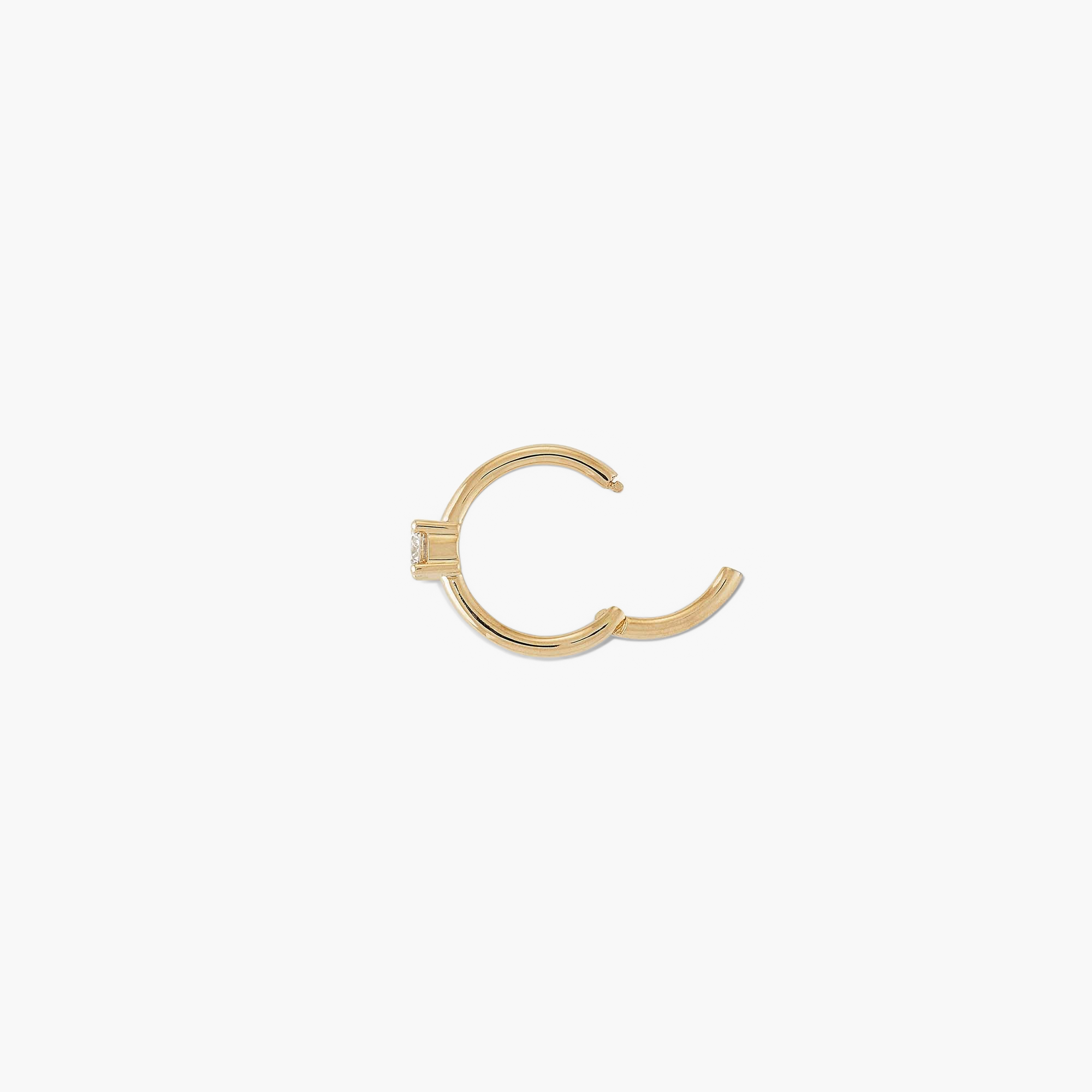 Cartilage Solo Diamond Mini Hoop: A close-up of a handcrafted 14k gold mini hoop earring with a hinge clasp, featuring a small diamond.