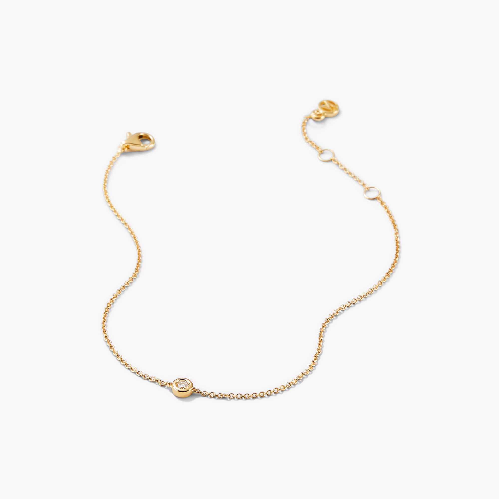 Solo Diamond Bracelet: A close-up of a solid gold bracelet featuring a round cut diamond in a bezel setting. Elegant and timeless design.