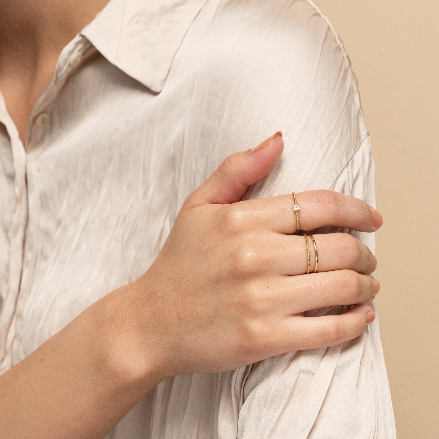 Close-up of a woman's hand wearing a Twist Ring, showcasing its elegant 1.3 mm twisted band design.