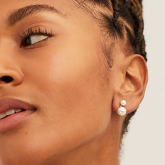 Close-up of a woman's face showcasing Essential Pearl Earrings, handcrafted in 14k solid gold with three finishes, highlighting elegance and sophistication.