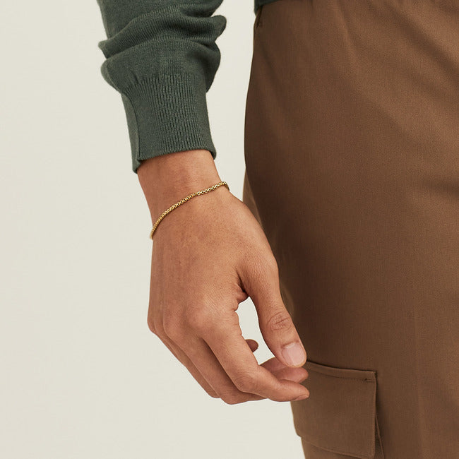 Hand wearing the Round Box Chain Bracelet, a simple gold chain designed for everyday wear, highlighting its comfortable fit and understated elegance.