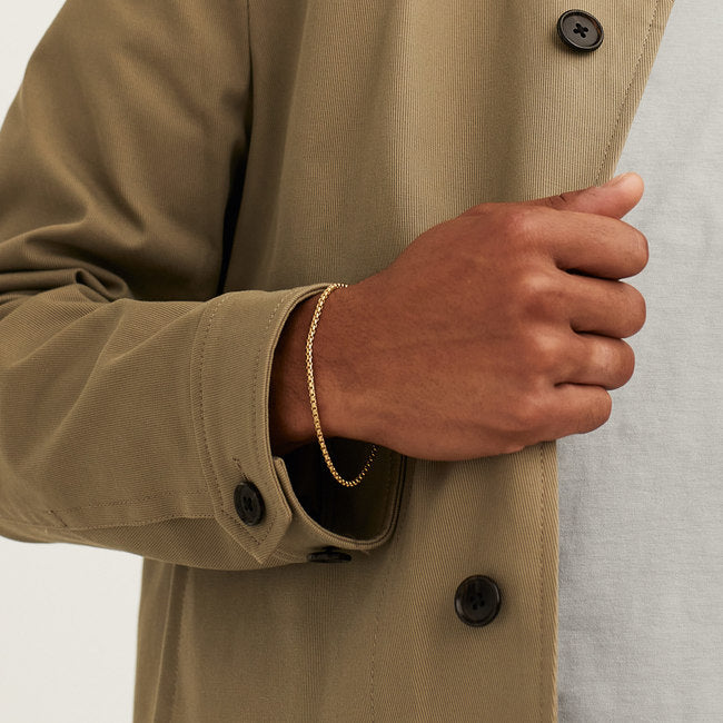 Person wearing a Round Box Chain Bracelet, a simple gold accessory suitable for daily wear.